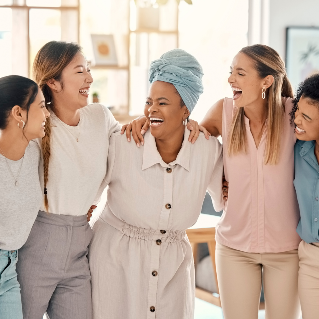diverse group of women in all different demographics laughing because they are happy that they considered diversity when they decide where to live; they are all dressed in a different tones of beige. location must haves  